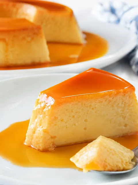 Porción de flan cremoso con caramelo brillante en plato blanco